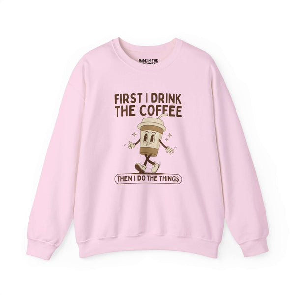Light pink sweatshirt with the phrase 'First I Drink the Coffee Then I Do the Things' featuring a coffee cup graphic.