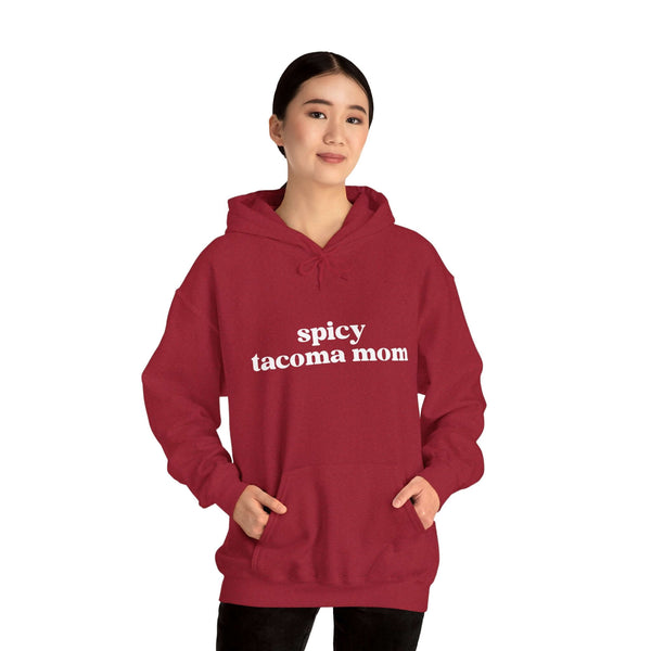 Woman wearing a Spicy Tacoma Mom hoodie, displaying grit and glam style in a bold red color.
