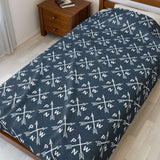 PNW Arrow Crossroads Lightweight Cozy Blanket with crossed arrows in a stylish pattern on a bed.