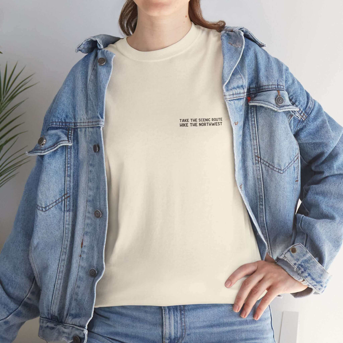 Woman wearing 'Take the Scenic Route' hiking tee under a denim jacket.