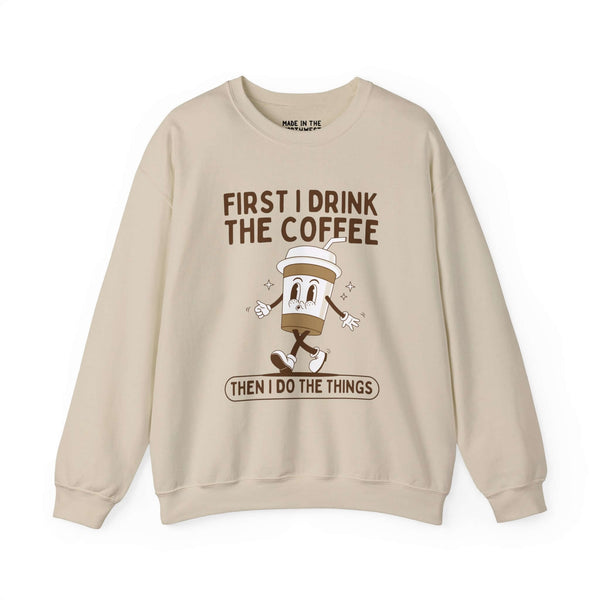 Beige sweatshirt with "First I Drink the Coffee Then I Do the Things" text and cartoon coffee cup design, perfect for coffee lovers.