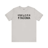 Home is in Tacoma tee showcasing a subtle campfire, Bigfoot, and tree design, ideal for expressing Grit City pride.