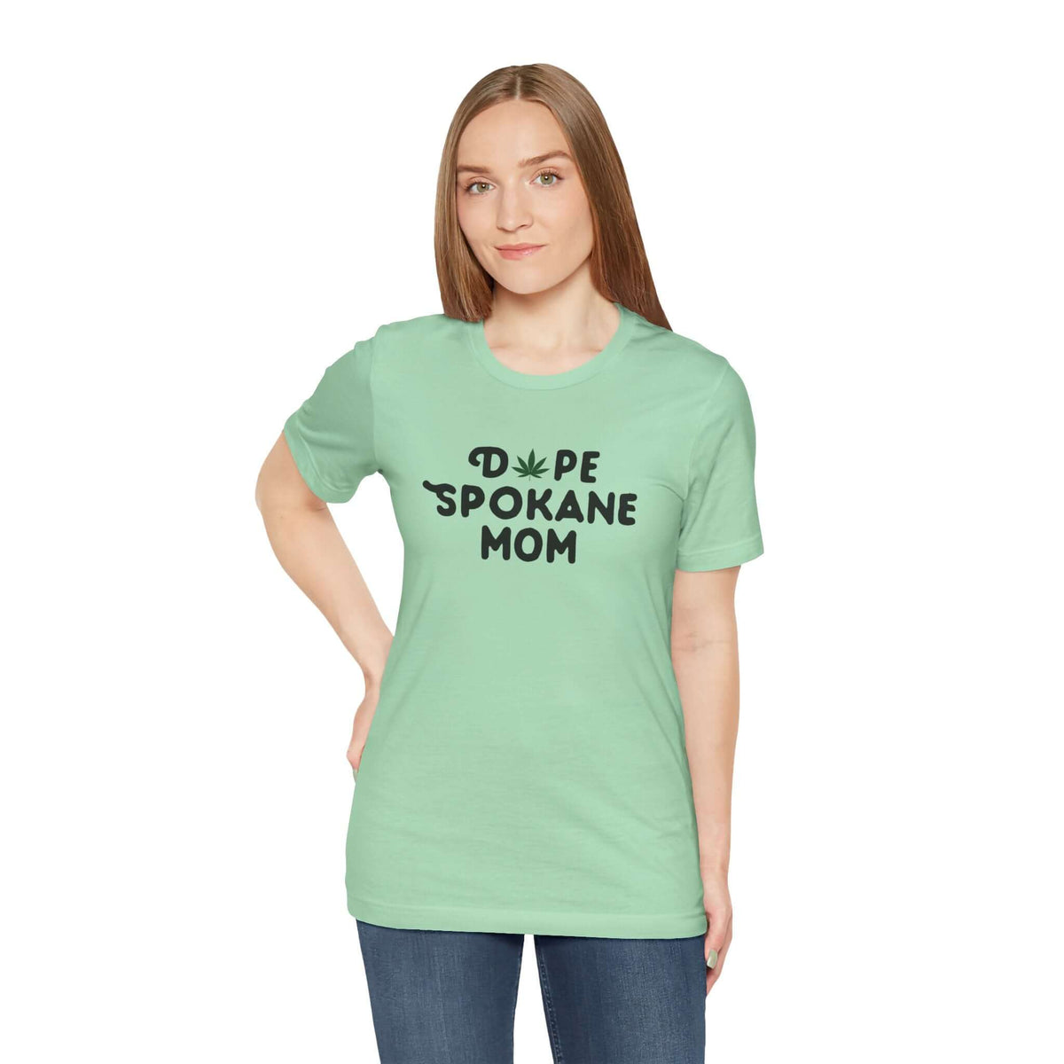 Model wearing a mint green 'Dope Spokane Mom' premium soft tee with a playful marijuana leaf design.