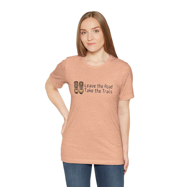 Woman wearing Leave the Road, Take the Trails soft tee, celebrating outdoor adventures and unpaved paths.