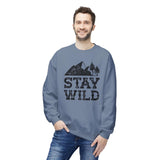 Stay Wild sweatshirt displayed by a smiling man, featuring a faded mountain and trees graphic in a cozy crewneck style.