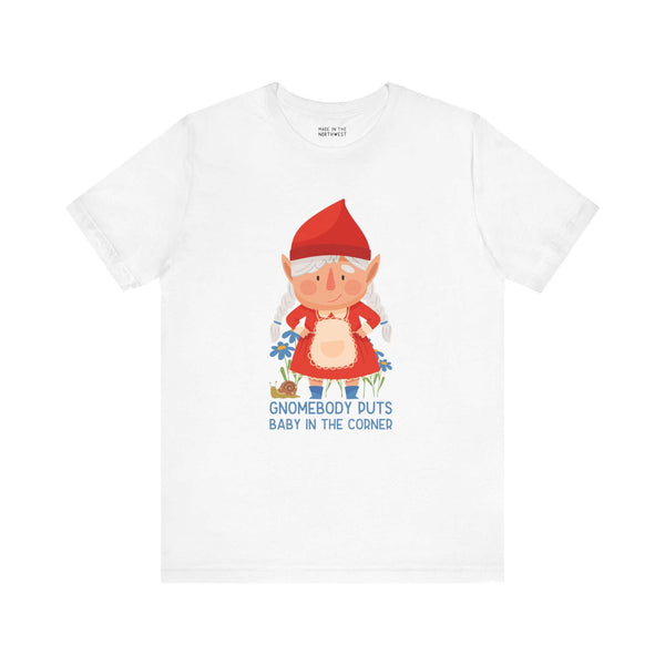 White tee featuring a cute female gnome with the text "Gnomebody Puts Baby in the Corner," inspired by a classic movie line.