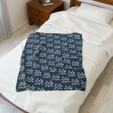 PNW Arrow Crossroads Lightweight Cozy Blanket displayed on a bed, featuring a stylish design with crossed arrows.