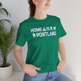 Home Is in Portland tee worn by a smiling woman, featuring campfire and tree designs, perfect for Rose City pride.