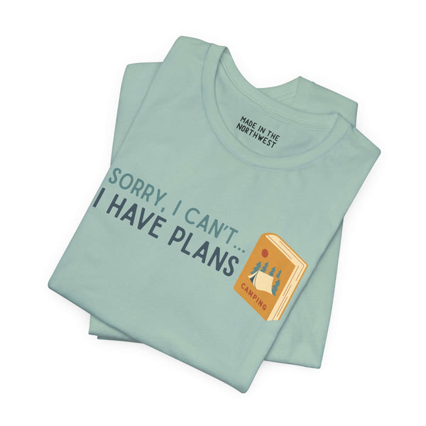 Sorry I Can't - I Have Camping Plans Premium Soft Tee in light blue color with outdoor and book graphics.