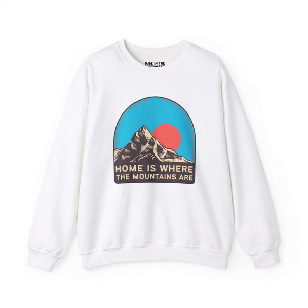 White sweatshirt with "Home is Where the Mountains Are" graphic featuring colorful mountain peaks and sky. Perfect for nature lovers.