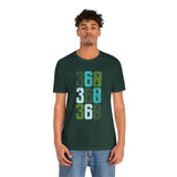 Man wearing green 'Three-Six-Oh Pop Soft Tee' with 360 area code design in bold colors, celebrating Pacific Northwest pride.