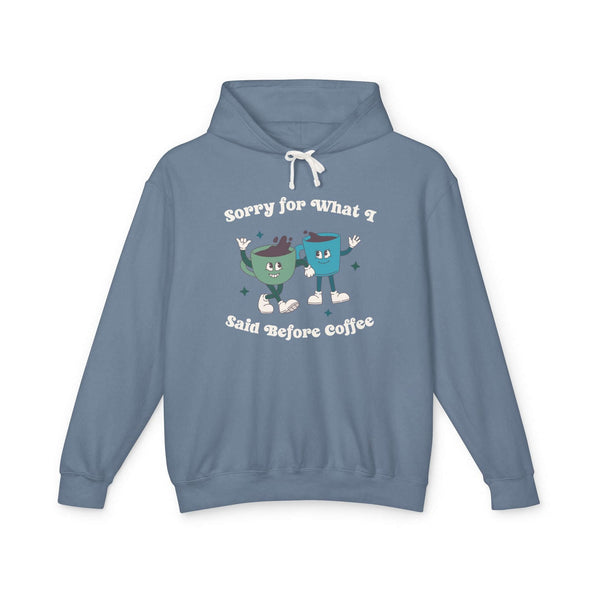 Blue hoodie with playful design saying 'Sorry for What I Said Before Coffee' with two cartoon coffee cups.