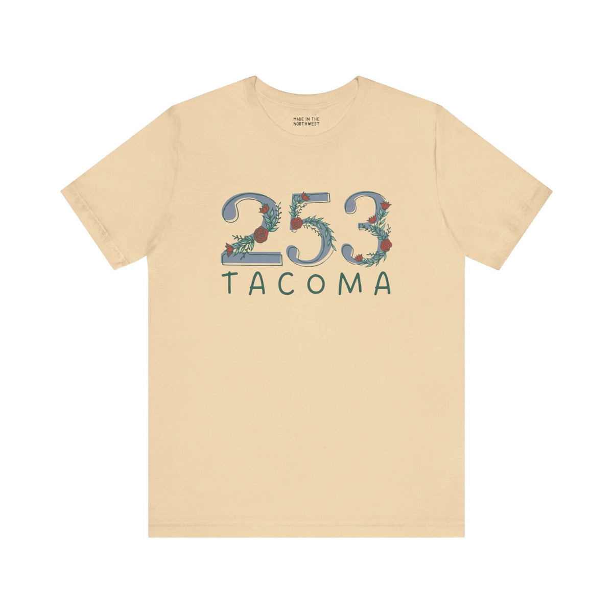 Beige tee with floral "253 Tacoma" design, representing Pacific Northwest pride and nature-inspired style.