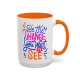 Be the Change You Want to See Mug with vibrant hand-lettered design and colorful orange handle.