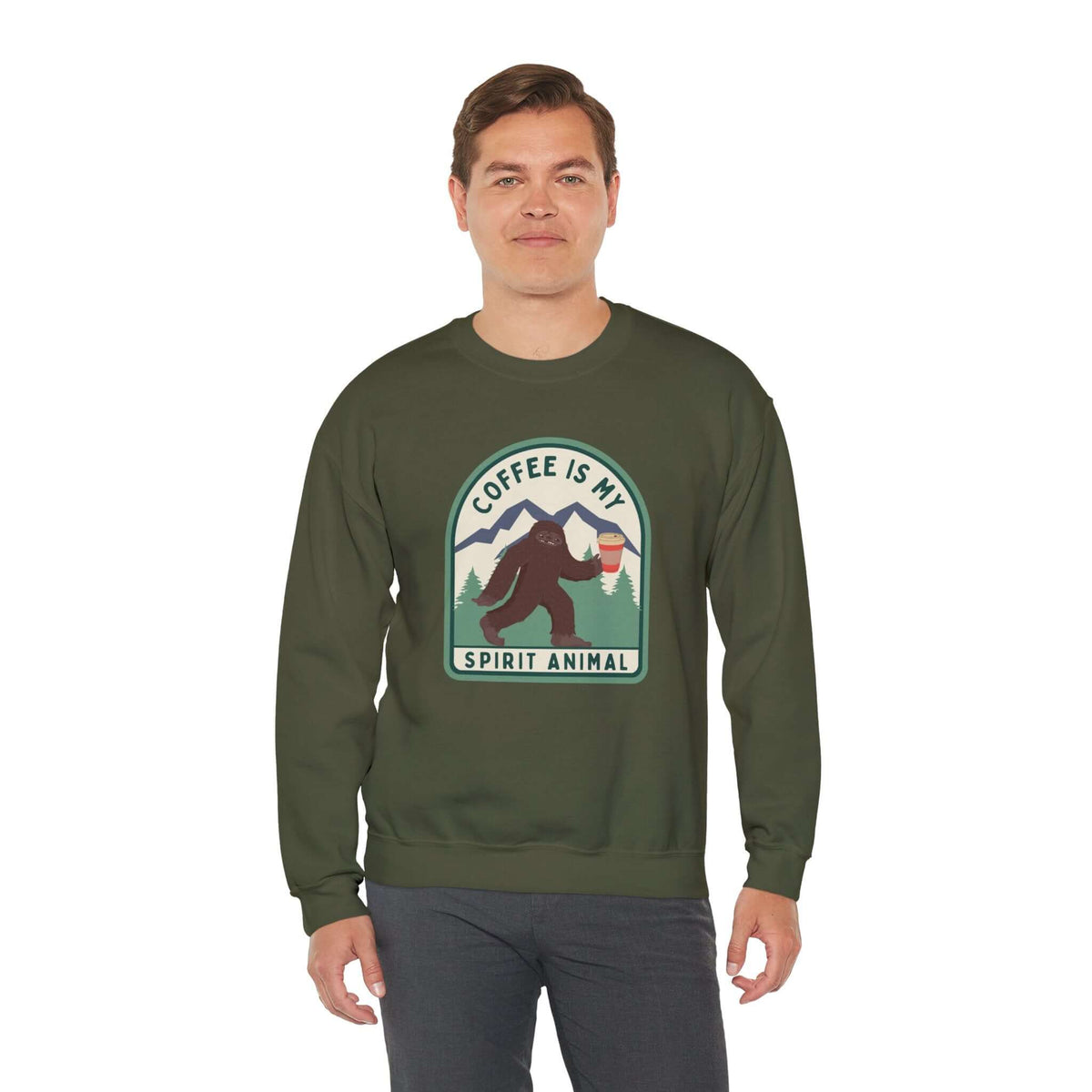 Man wearing a green sweatshirt with Sasquatch holding coffee and text "Coffee Is My Spirit Animal," perfect for coffee enthusiasts.