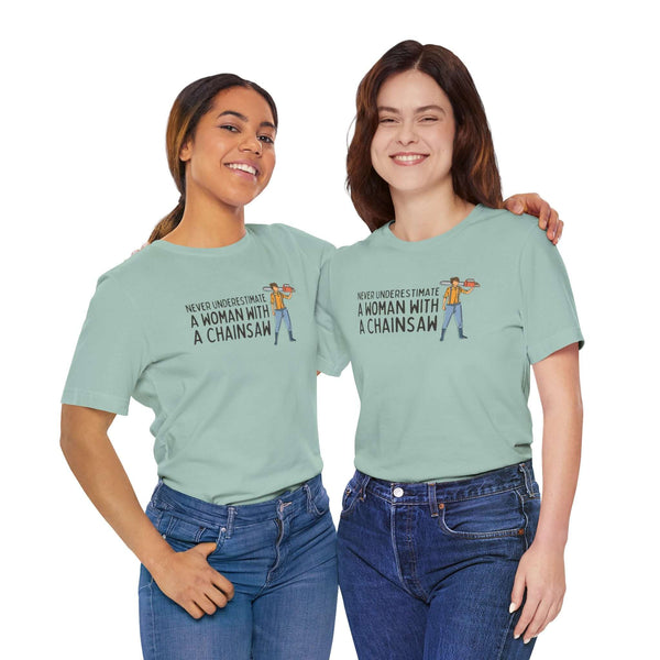 Two women wearing the Never Underestimate a Woman with a Chainsaw premium soft tee, showcasing strength and confidence.