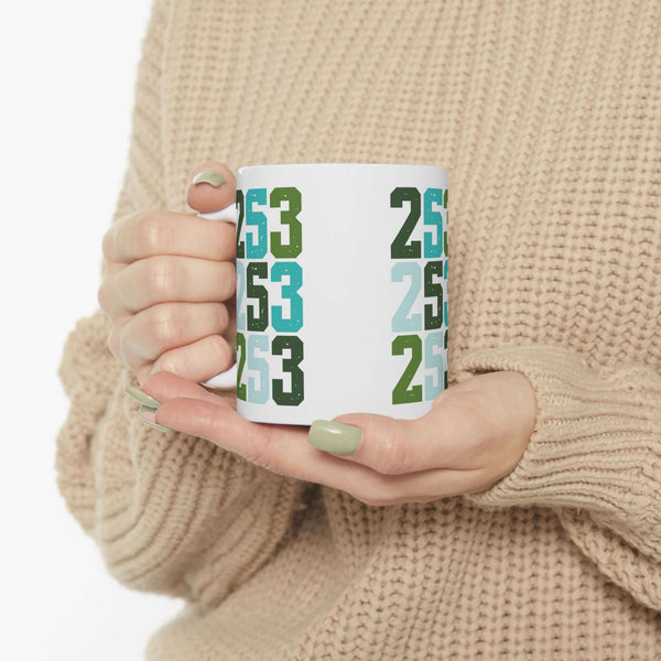 Two-Five-Three Pop Tacoma Ceramic Mug with colorful area code design in hands, perfect for coffee lovers.