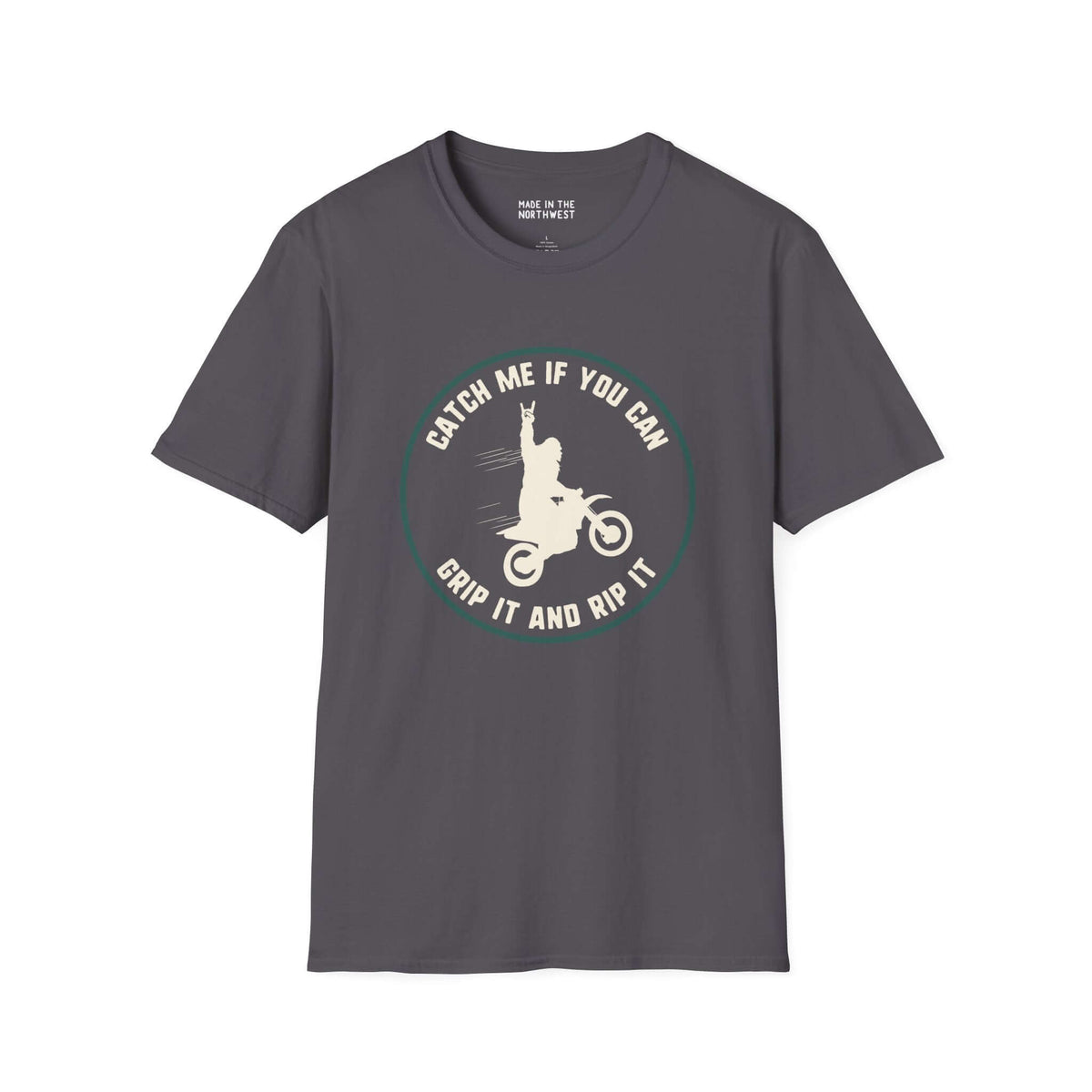 Gray softstyle t-shirt featuring a Bigfoot motocross design with the text 'Catch Me If You Can, Grip It and Rip It'.