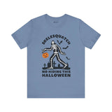 Skelesquatch Halloween soft tee featuring skeleton Sasquatch, graveyard scene, and trick-or-treat bucket on blue shirt.