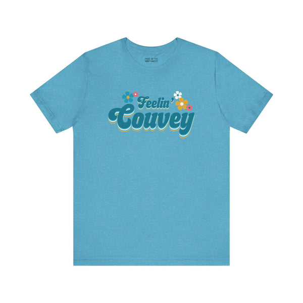 Feelin' Couvey Retro Soft Tee Embrace the vibrant spirit of Vancouver, Washington with our "Feelin' Couvey" Retro Tee! This playful design features the phrase "Feelin' Couvey" in a nostalgic 70s font, complete with colorful aqua and pink flowers. A fun tw