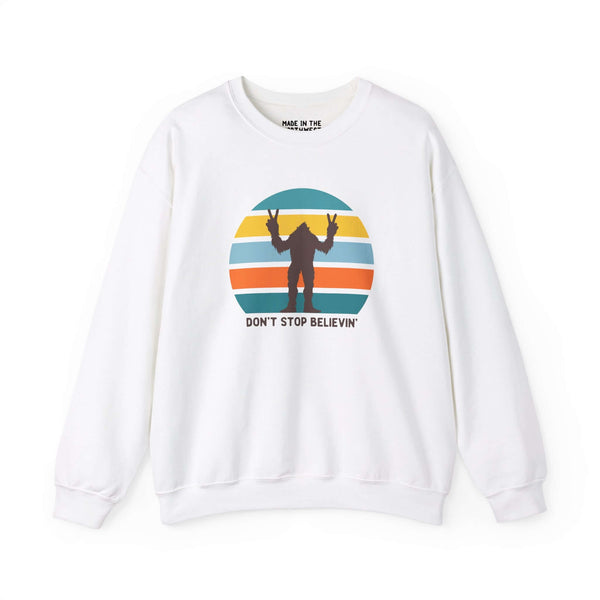 Don't Stop Believin' Bigfoot sweatshirt featuring a playful sasquatch graphic and colorful stripes.