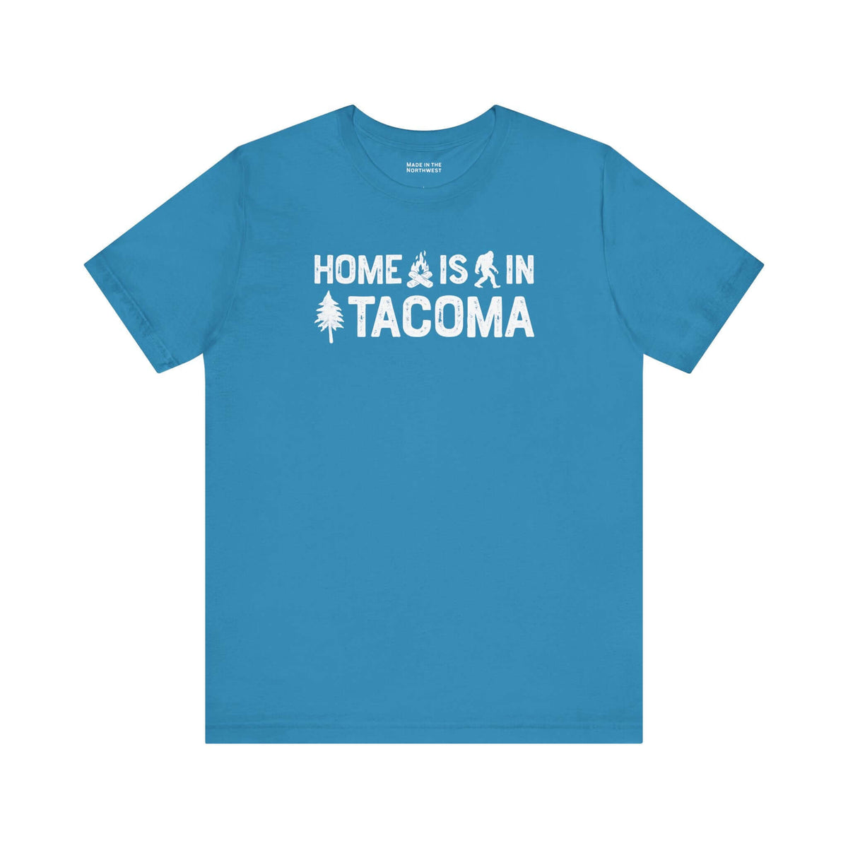 Home is in Tacoma tee in blue featuring campfire, Bigfoot, and tree designs to represent Tacoma's pride.