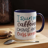 I Run on Caffeine, Chaos and Cuss Words Mug with colorful text and a blue interior, placed on a wooden surface.