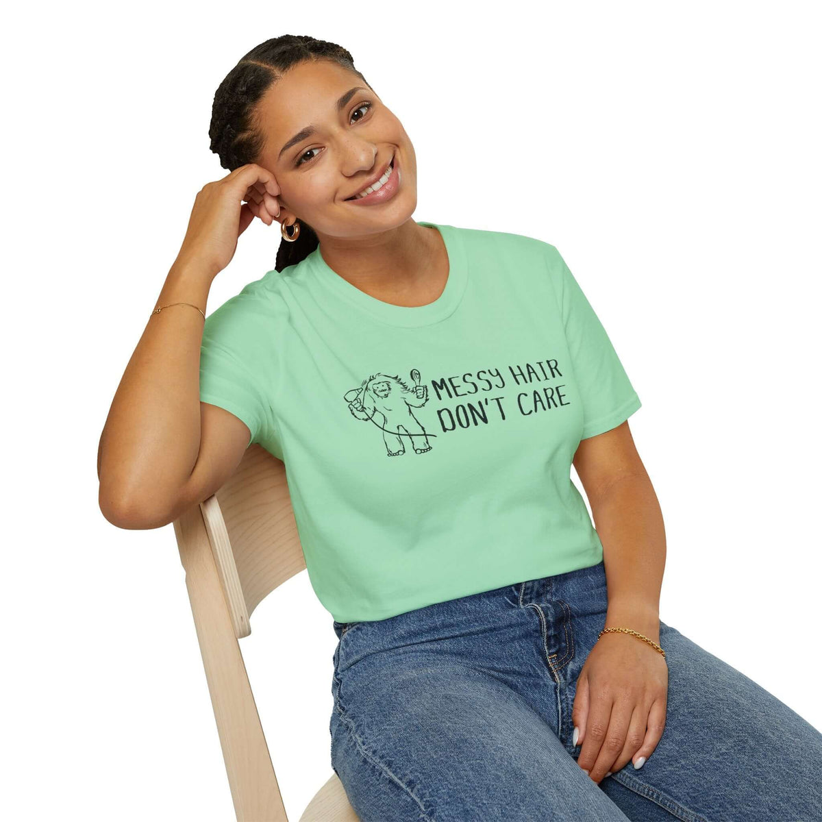 Messy Hair Don't Care Bigfoot T Shirt worn by a smiling woman sitting on a chair, showcasing confident style.
