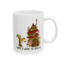 Ceramic mug featuring a gnome and cozy mushroom house with text 'Gnome Is Where The Heart Is'.