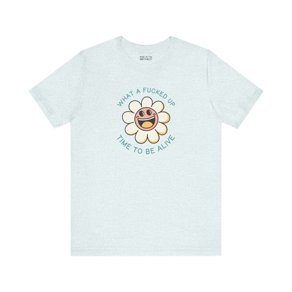 Light teal t-shirt featuring a smiling daisy and the text 'What a F*cked Up Time to Be Alive'.