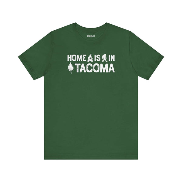 Home is in Tacoma tee in green color featuring Bigfoot and tree graphics.