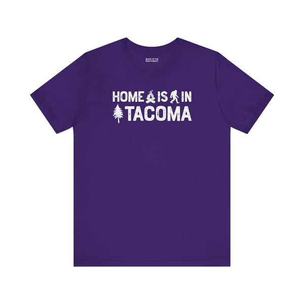 Home is in Tacoma tee on a purple shirt with Bigfoot and campfire graphic design.