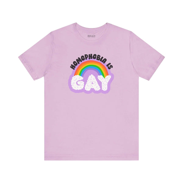 Homophobia Is Gay T shirt featuring colorful rainbow design on a light purple background.