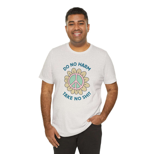 Man wearing a soft tee with 'Do No Harm, Take No Sh!t' design featuring a peace flower.