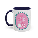 Be Your Own Hero Mug with playful pink badge and teal scallops on a glossy ceramic surface.
