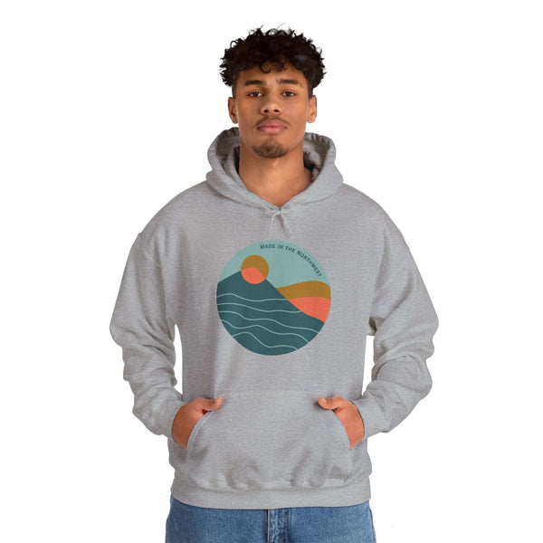 Gray hoodie with Pacific Peaks Modern Circle design showing a vibrant mountain scene, worn by a model, perfect for outdoor enthusiasts.