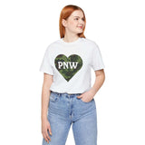 Woman wearing Camouflage PNW Heart Soft Tee, white shirt with a camo heart featuring 