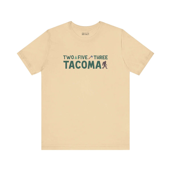 Beige "Two Five Three Tacoma" tee with axe and tree design, celebrating Tacoma pride and style.