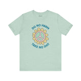 Do No Harm Take No Shit Tee featuring a peace flower design on a mint green t-shirt.