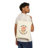 Person carrying a cream tote bag with the text 