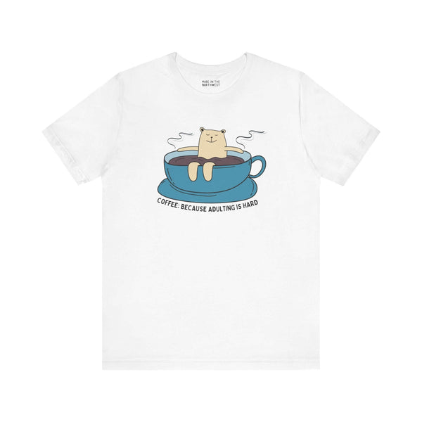 White tee with cartoon bear in a coffee cup and text 'Coffee: Because Adulting is Hard'.