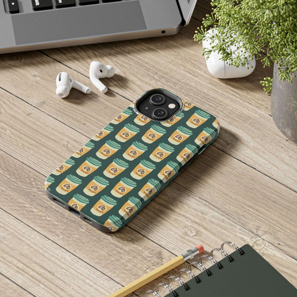 East Meets Roast tough phone case featuring a coffee cup design on a wooden desk with accessories.