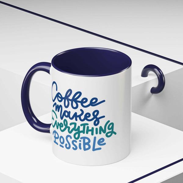 Coffee Makes Everything Possible Mug with hand-lettered design and navy interior on a clean desk.