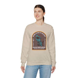 Woman wearing a beige Born to Be in the Dirt sweatshirt featuring a rugged outdoor adventure design.