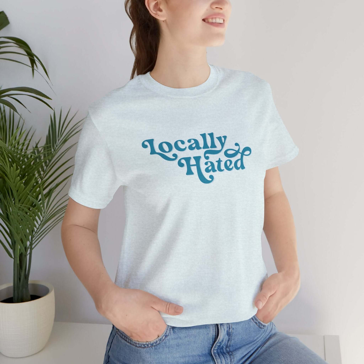 Woman wearing a "Locally Hated" soft tee with bold cursive font, perfect for making a statement in the Pacific Northwest.