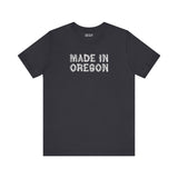 Black tee featuring 'Made in Oregon' in rustic log font, celebrating Pacific Northwest heritage and outdoor lifestyle.