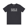Black tee featuring 'Made in Oregon' in rustic log font, celebrating Pacific Northwest heritage and outdoor lifestyle.