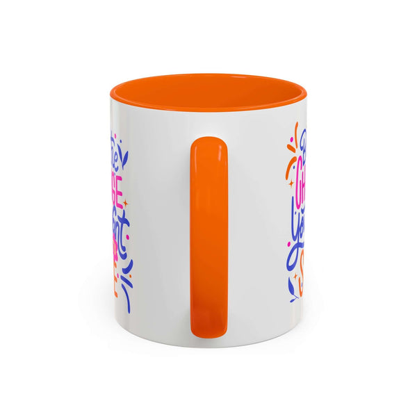 Be the Change You Want to See Mug with colorful hand-lettered design and orange interior.