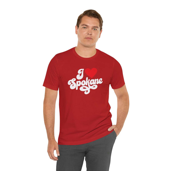 I love Spokane t shirt displayed on a model, featuring a red design with cursive text expressing hometown pride.