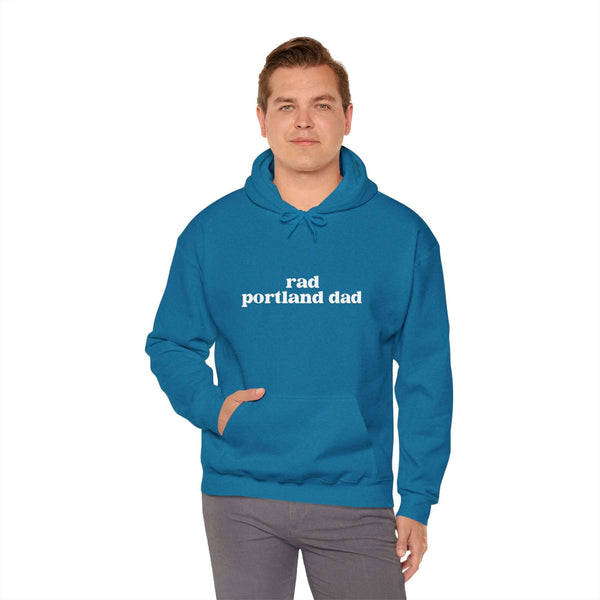Man wearing a blue Rad Portland Dad hoodie, showcasing local pride and humor in a casual style.